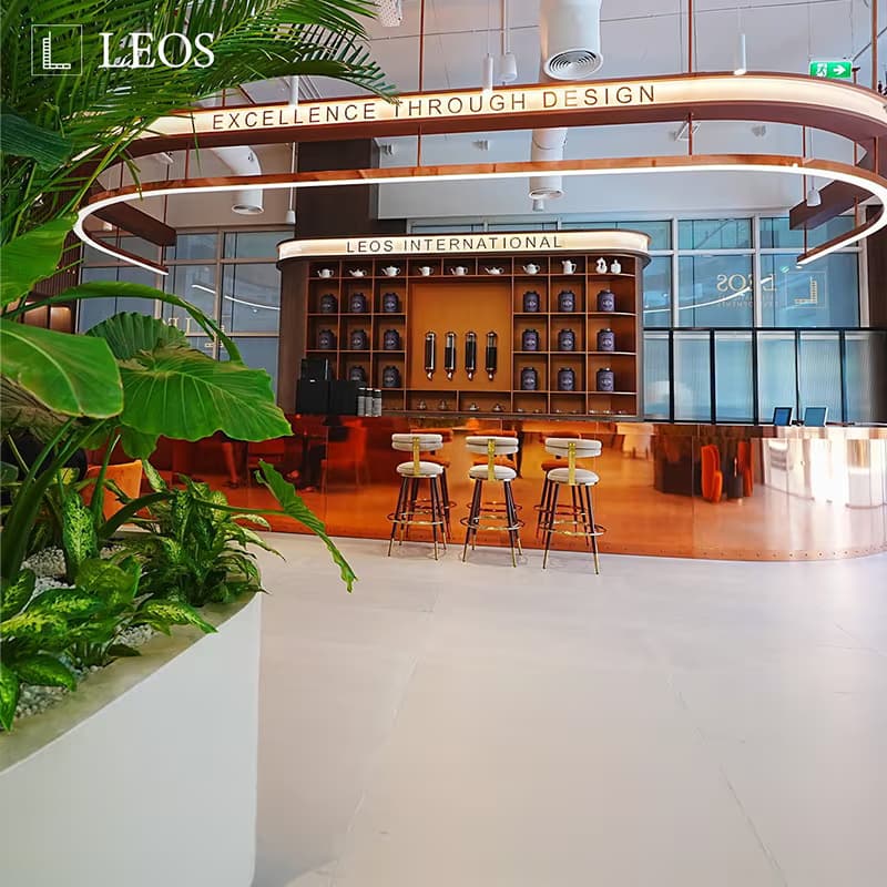 LEOS experience centre interior creative captioned Excellence Through Design, showing the lounge and bar with a curved ceiling light feature