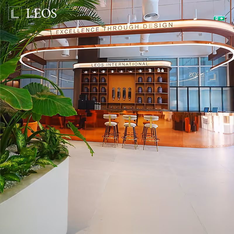 LEOS experience centre interior creative captioned Excellence Through Design, showing the lounge and bar with a curved ceiling light feature